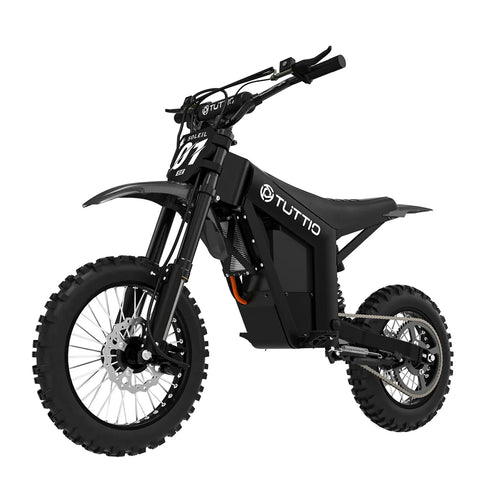 Motocyklista w kasku ochronnym siedzący na czarnym elektrycznym motocyklu Tuttio Soleil 01 SE na mokrej, asfaltowej drodze osiedlowej podczas opadów deszczu lub śniegu.